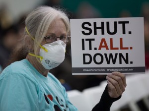 PORTER RANCH, CA - JANUARY 16: A woman holds a sign while attending a public hearing before the South Coast Air Quality Management District (AQMD) regarding a proposed stipulated abatement order to stop a nearby massive natural gas leak, on January 16, 2016 in Granada Hills, near Porter Ranch, California. More than 80,000 metric tons of methane gas have spewed from the Aliso Canyon natural gas storage facility since October 23, causing thousands of Porter Ranch residents to leave their homes, and the closures of two schools where students are being bussed to campuses farther away from the gas. State officials are now concerned that a seventh attempt to plug the well may have increased the chance of a blowout, which would greatly increase the release of gas as well as the risk of a massive well fire if ignited by a spark. The Southern California Gas Company (SoCalGas) hopes to repair the leak by sometime in March. (Photo by David McNew/Getty Images)